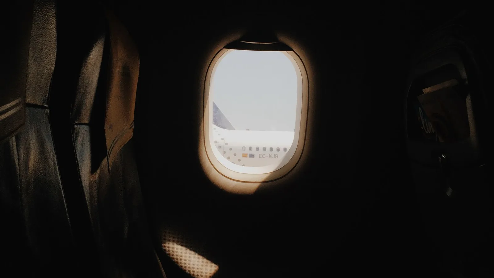 機内の窓越しに見える空港の航空機