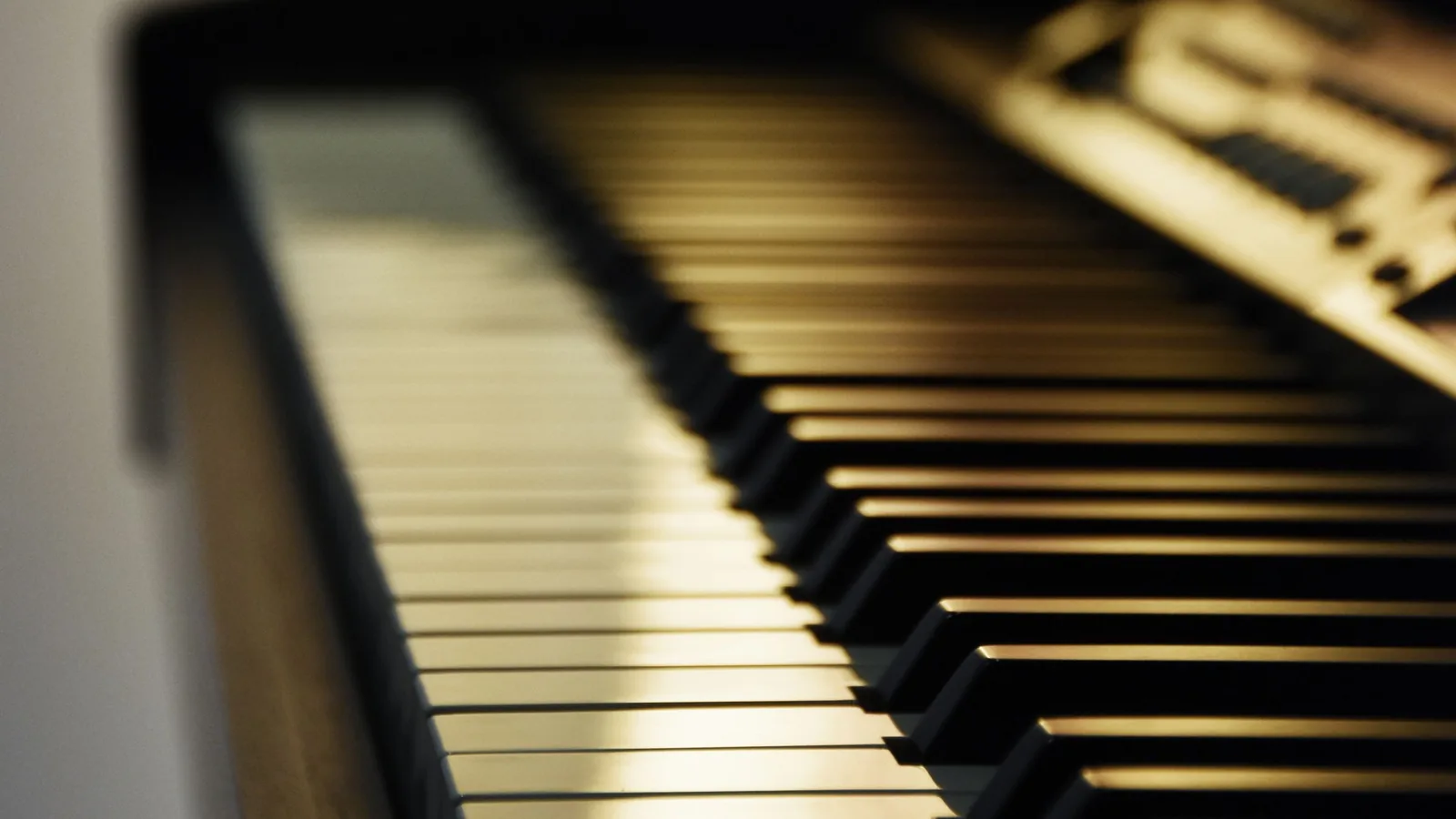 柔らかな光に照らされたグランドピアノの鍵盤